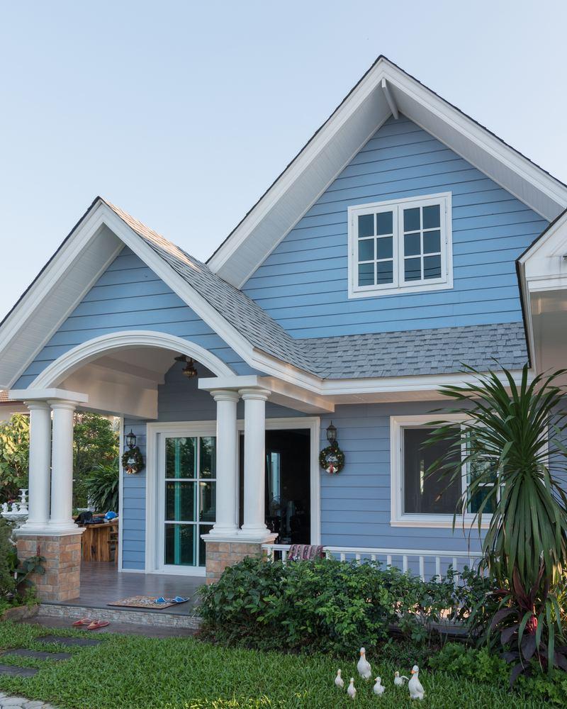 A vibrant tropical beach house featuring bold color palettes of turquoise and coral, evoking a fun vacation atmosphere