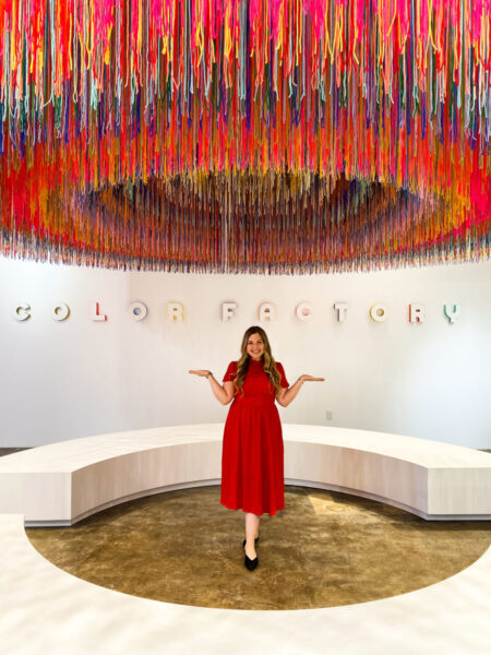A woman in red dress standing in front of a reception