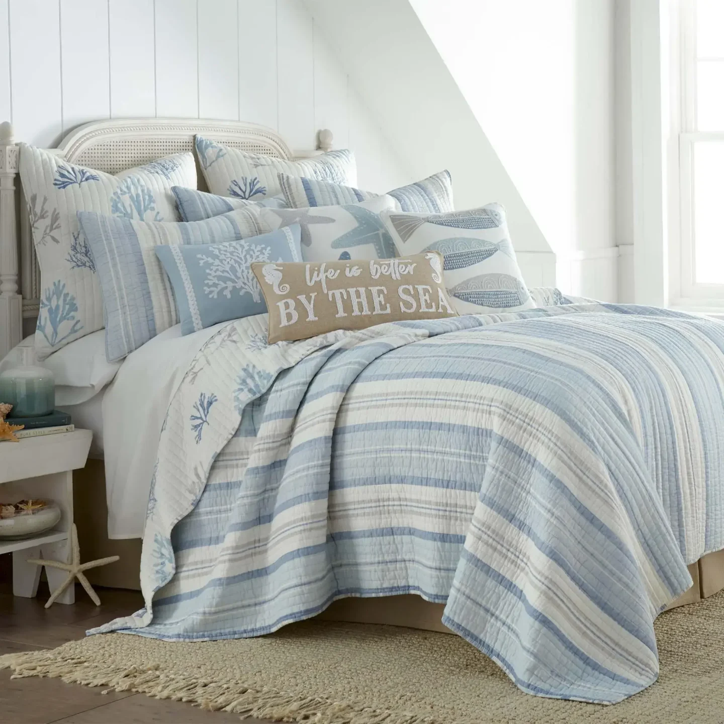 Nautical striped bedding in navy and white creates a breezy coastal vibe, paired with white linens and textured accents for warmth