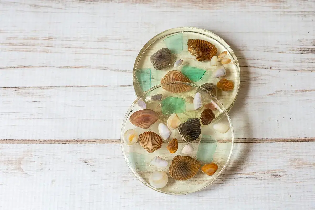 Handmade sea glass coasters arranged on a beach-themed ta
