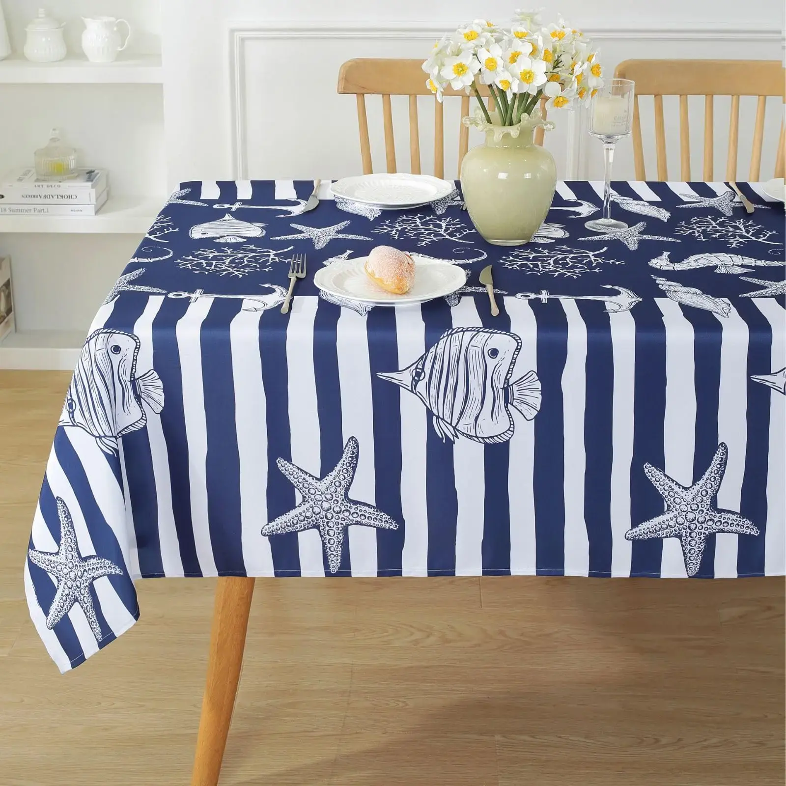 A beach-themed table set with nautical tablecloths, featuring seashells and ocean motifs for a coastal dining experience