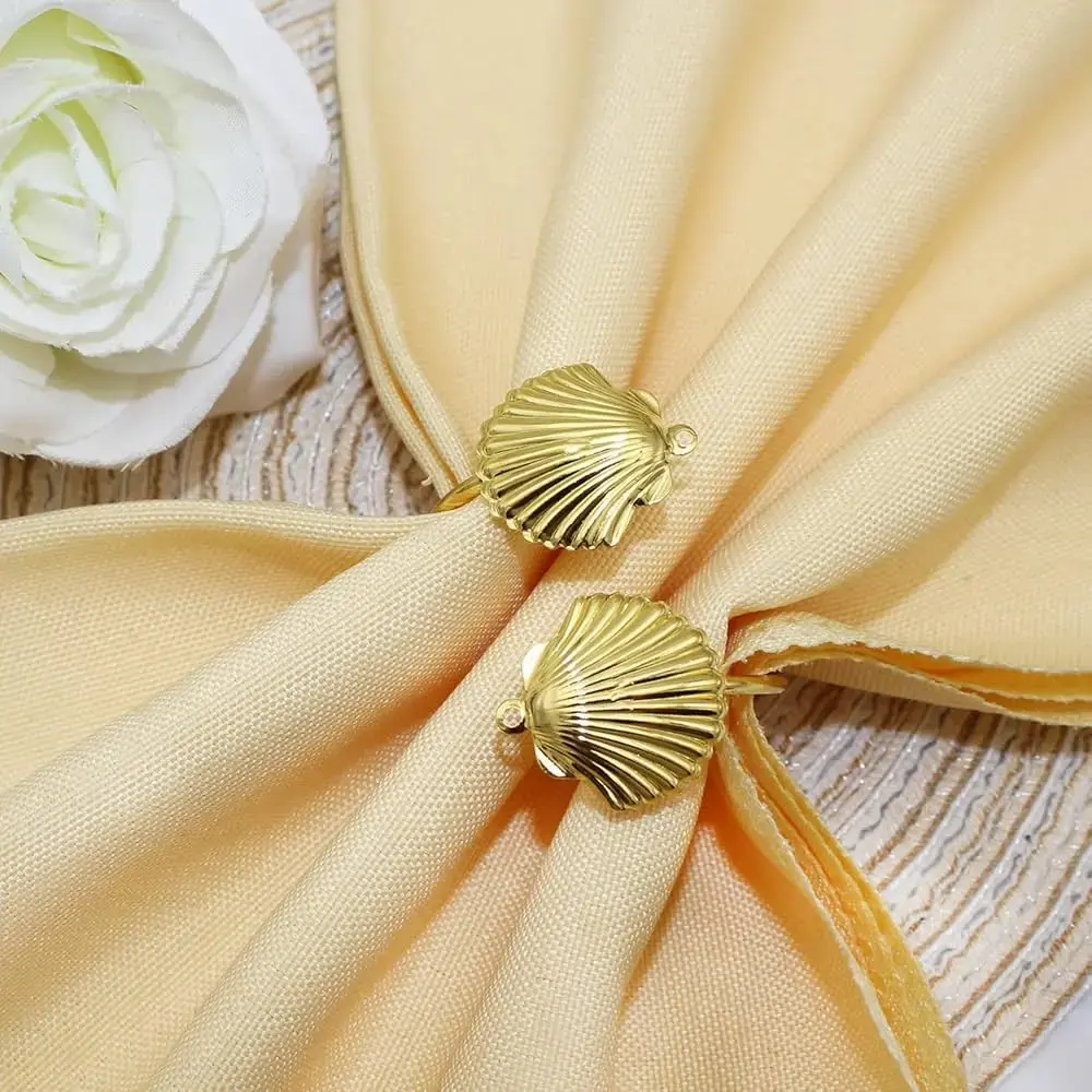 elegant seashell napkin rings arranged on a light-colored tablecloth