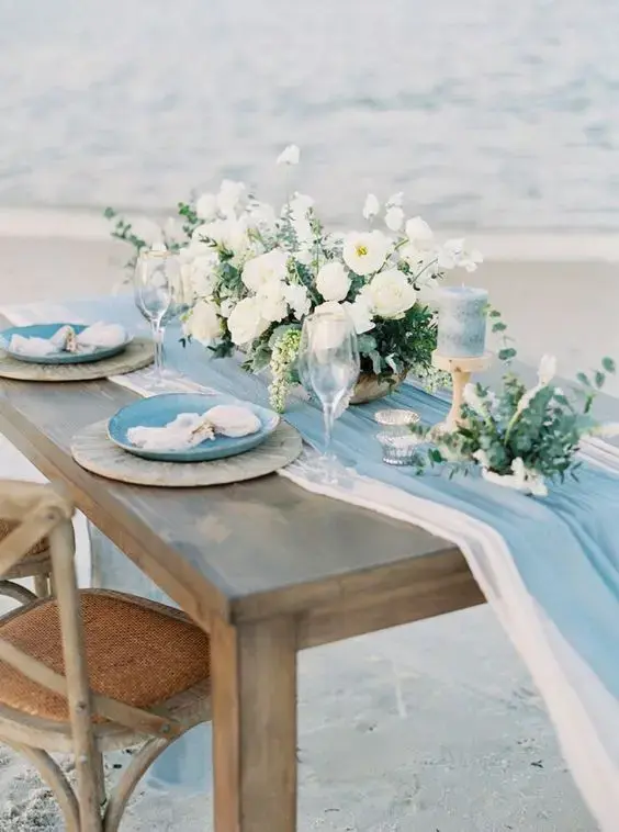 Beach-themed table decor featuring vibrant table runners with ocean motifs and sandy colors for a coastal ambiance
