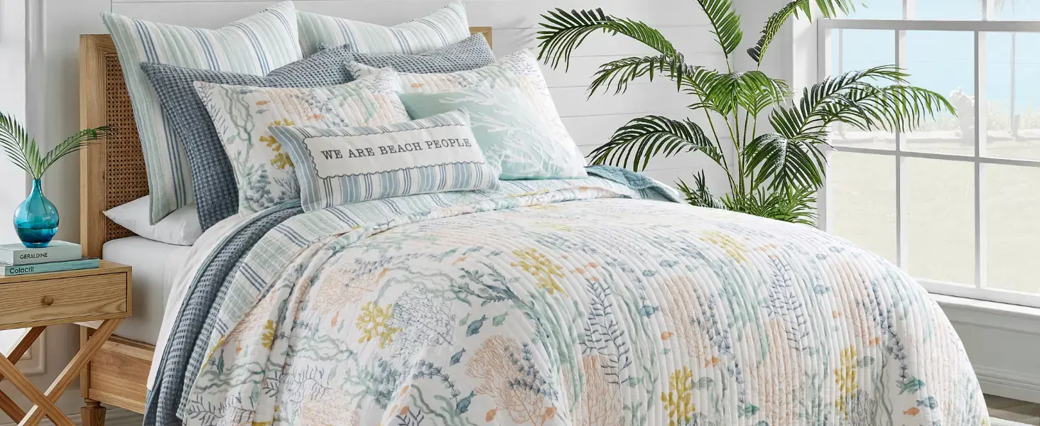 Soft blue, green, and peach floral prints create a romantic, vintage-inspired aesthetic in a beachy bedroom setting