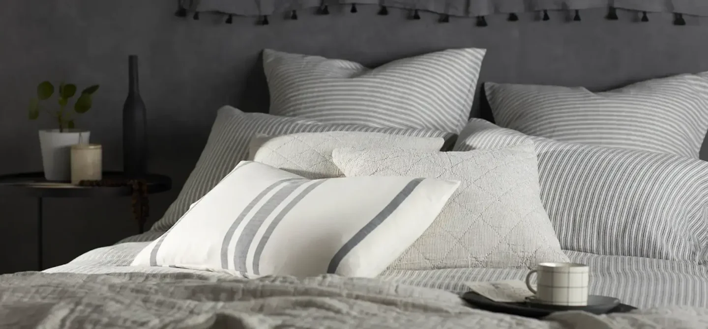 Vibrant stripes in coral, teal, and mustard provide a fresh costal bedroom