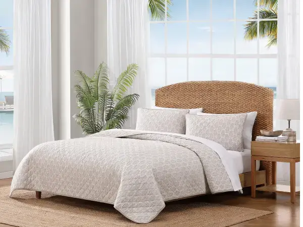 Coastal bedding in muted blue, gray, and beige hues, creating a relaxed, vintage beach cottage aesthetic
