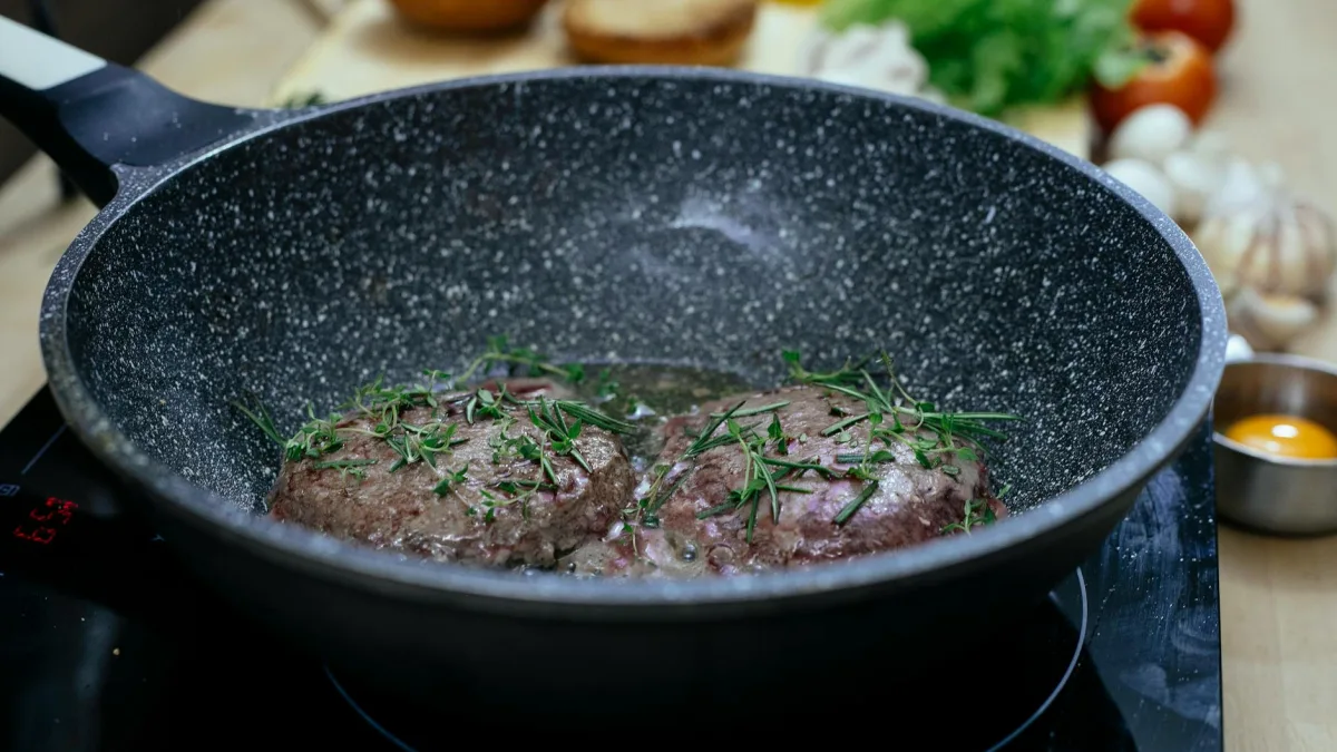 Cast iron skillet on stovetop with melted butter ready for French toast cooking